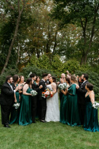 Bride and Groom Kissing With Wedding Party Dark Green Palette