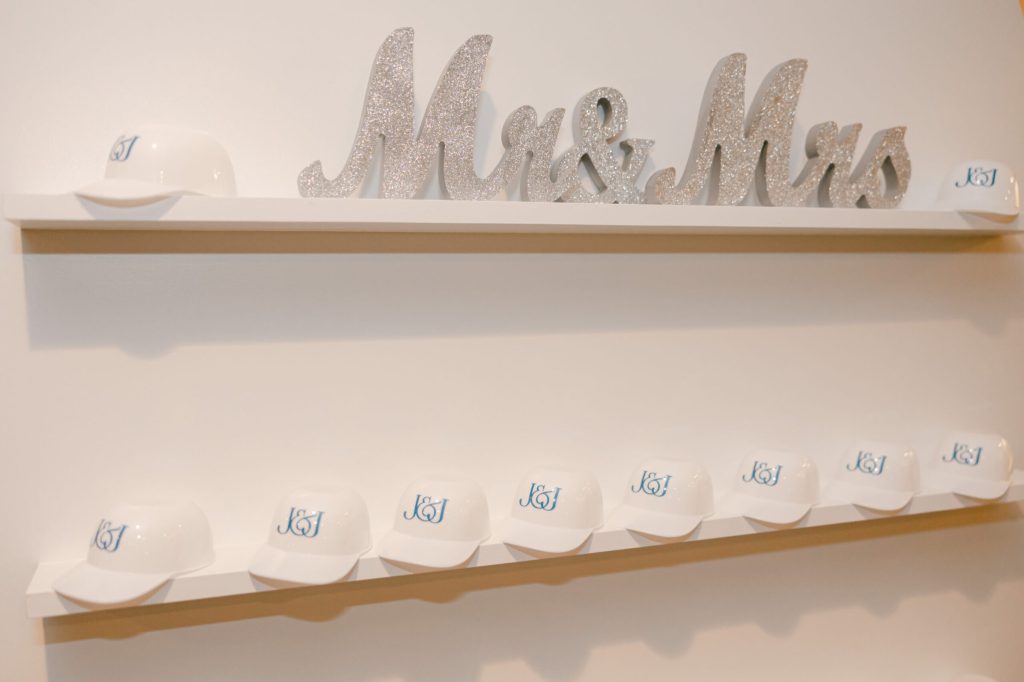 Sparkly Mr & Mrs sign on a shelf above a row of white caps.