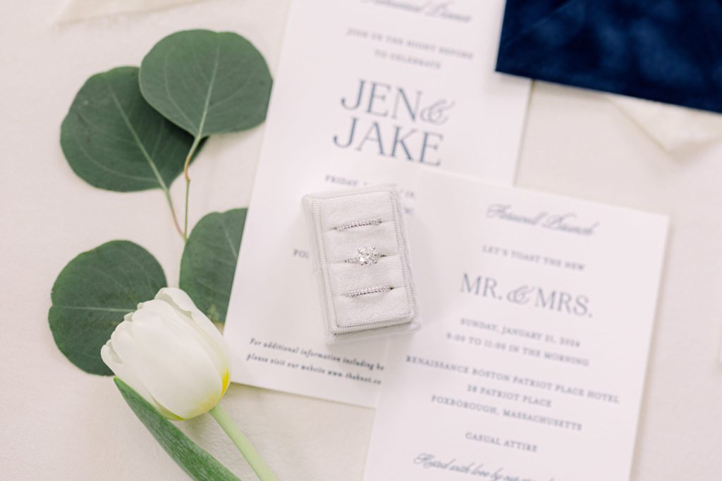 Wedding invitation suite with a ring box and eucalyptus.
