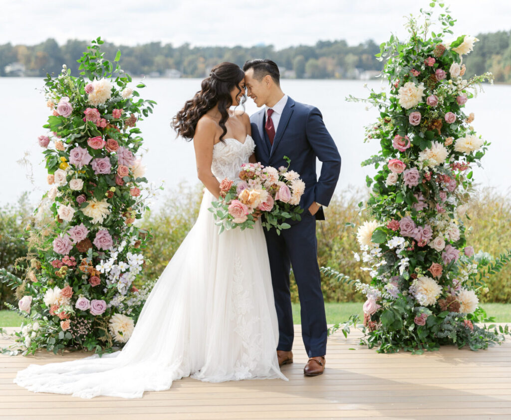bride and groom with romantic wedding theme in front of a lake