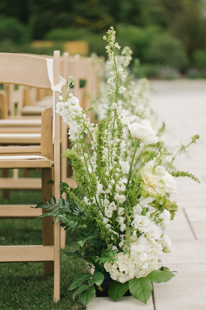 Outdoor ceremony aisle green and white floral decor