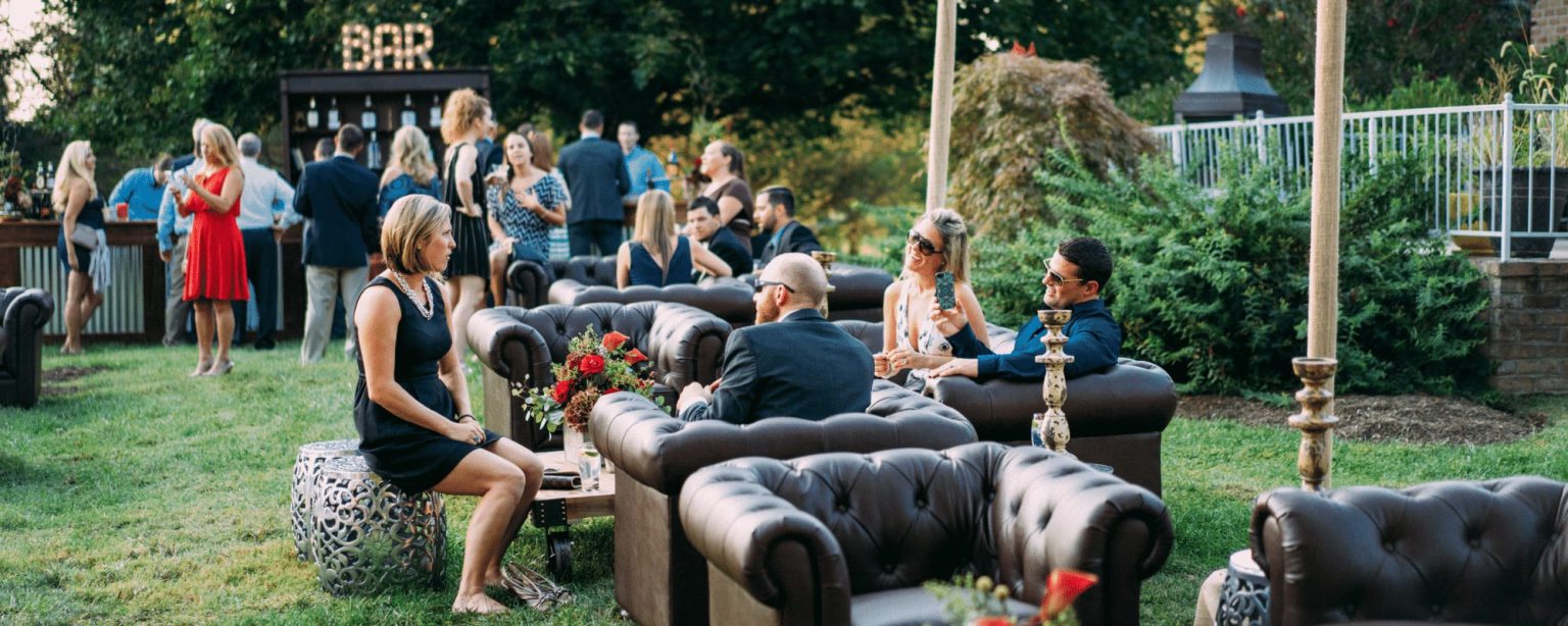 Guests relaxing on leather lounge sofas beside an outdoor bar