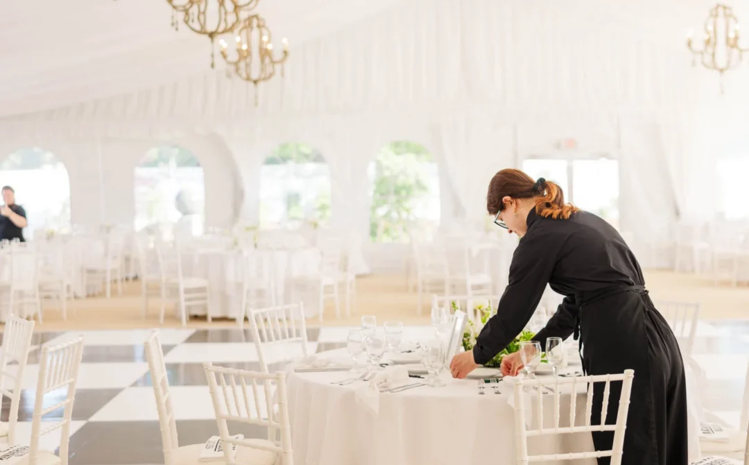 Saphire Event Group staff member setting tables in the Tent at The Villa in East Bridgewater, MA